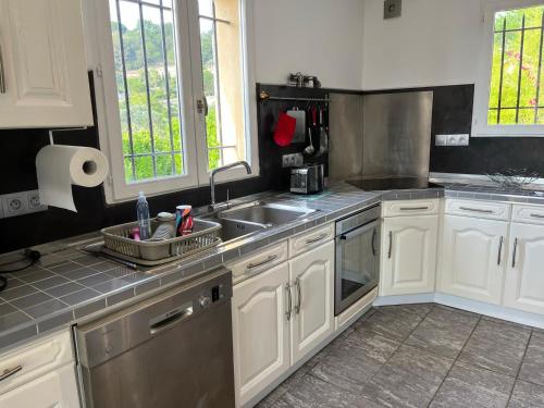 a kitchen with white cabinets and a sink at villa plaisirs in Saint-Paul-de-Vence