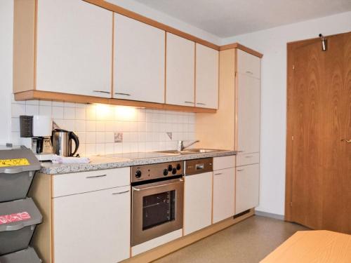 a kitchen with white cabinets and a stove top oven at Holiday Home Subretta-5 by Interhome in Kappl
