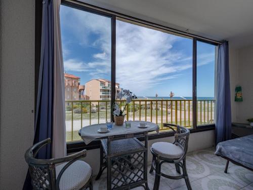 un balcon avec une table et des chaises et une vue sur l'océan dans l'établissement Apartment Palm Beach-5 by Interhome, au Barcarès