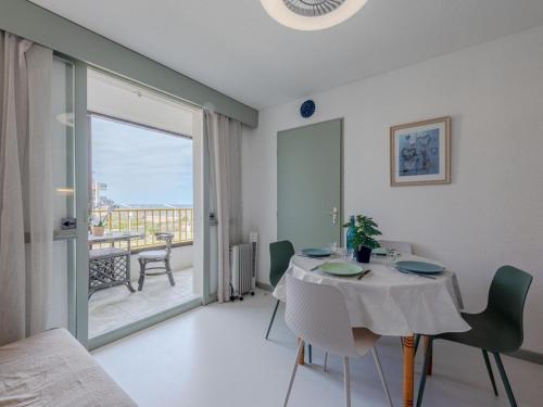 une salle à manger blanche avec une table et un balcon dans l'établissement Apartment Palm Beach-5 by Interhome, au Barcarès