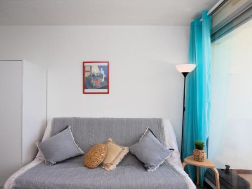 - un salon avec un canapé gris et des oreillers dans l'établissement Apartment Du Soleil-3 by Interhome, à La Grande Motte