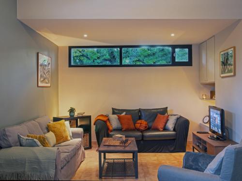 un salon avec deux canapés et une télévision dans l'établissement Holiday Home Villa Isabelle by Interhome, à Gondonnets