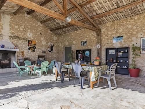 a patio with tables and chairs in a stone building at Holiday Home Bastide du 19ième by Interhome in Oppède