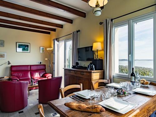 ein Esszimmer mit einem Tisch und einem Sofa in der Unterkunft Holiday Home Les Roches - LPU 103 by Interhome in Clohars-Carnoët