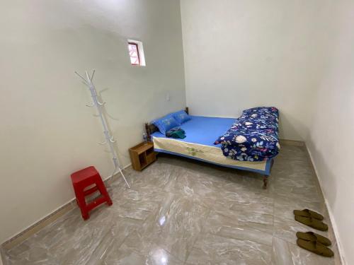 a small room with a bed and a red stool at Motel Homestay Tiến Học in Mia Xu
