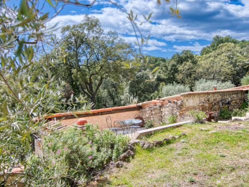 a garden with a stone wall and trees at Holiday Home Chez Canard by Interhome in Ampus