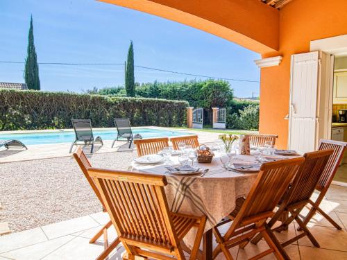 een tafel en stoelen op een patio met een zwembad bij Holiday Home Villa Faro - MFT100 by Interhome in Montfort-sur-Argens