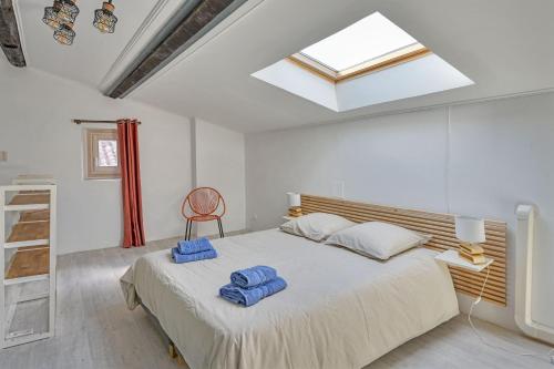 um quarto com uma cama com toalhas azuis em Oasis Provencale - Clim - Wifi em Avignon