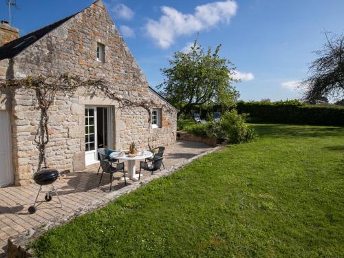 une maison en pierre avec une table et des chaises dans une cour dans l'établissement Holiday Home Bienvenue by Interhome, à Loctudy