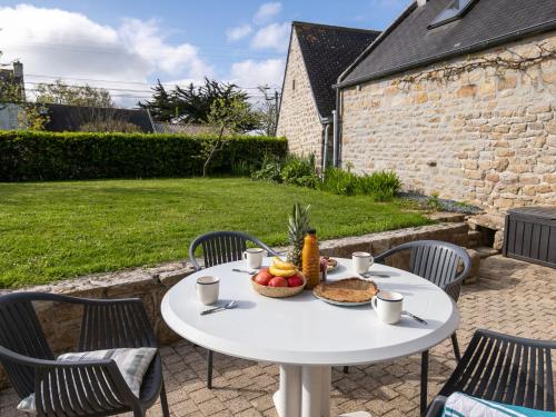 - une table blanche avec un bol de fruits sur la terrasse dans l'établissement Holiday Home Bienvenue by Interhome, à Loctudy