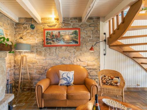 un fauteuil en cuir dans une chambre avec un mur en pierre dans l'établissement Holiday Home Bienvenue by Interhome, à Loctudy