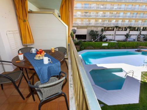 a table and chairs next to a swimming pool at Apartment Las Americas by Interhome in Lloret de Mar