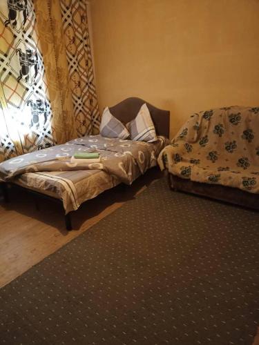 1 dormitorio con cama y sofá en Тимур, en Tokmok