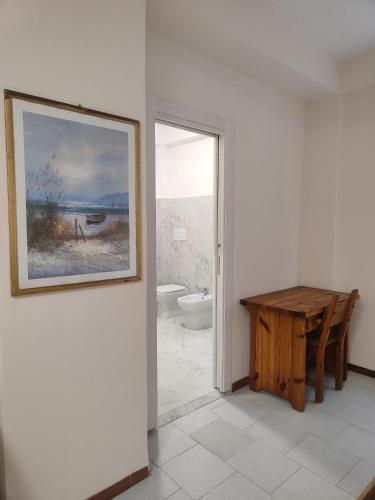 a bathroom with a table and a painting on the wall at FONDO VERSACE in Reggio di Calabria