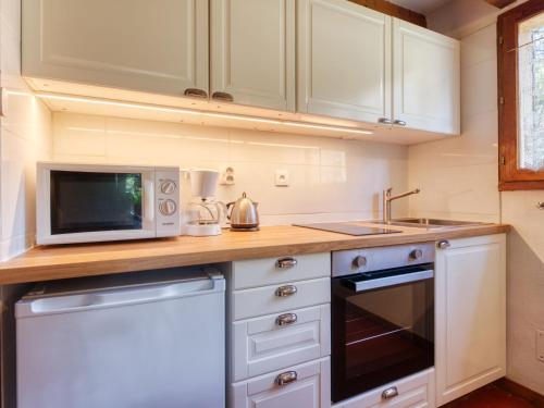 a small kitchen with a microwave and a stove at Holiday Home Les As-2 by Interhome in Lacanau-Océan