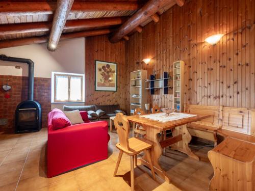 a living room with a table and a red chair at Apartment Marguerettaz-2 by Interhome in Sarre