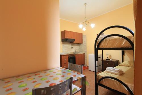 a bedroom with a bunk bed and a kitchen at Affittacamere Casa di Elide in Fondi