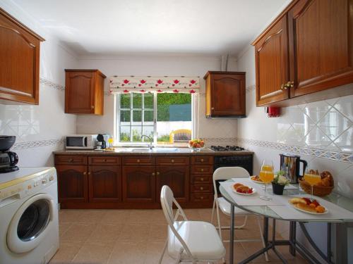 a kitchen with wooden cabinets and a table and a window at Holiday Home Monte Novo by Interhome in Paderne