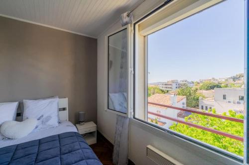 une chambre avec un lit et une grande fenêtre dans l'établissement La perle de Coco, à Marseille