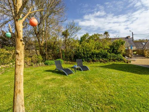 クロゾンにあるHoliday Home Du Bout du Monde - CZN141 by Interhomeの木の横の芝生に座る椅子2脚