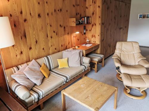 uma sala de estar com um sofá e duas cadeiras em Apartment Utoring Acletta-54 by Interhome em Disentis