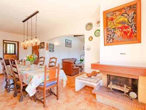 a dining room with a table and a fireplace at Holiday Home Le Mas d'Olive - GRI230 by Interhome in Grimaud