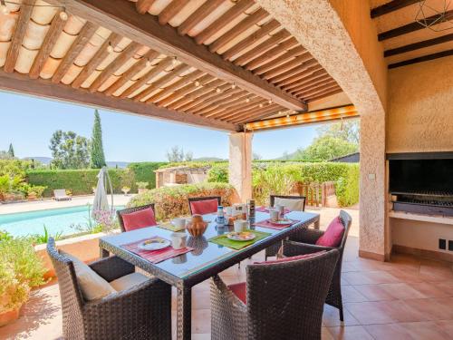 un patio avec une table et des chaises et une piscine dans l'établissement Holiday Home Le Mas d'Olive by Interhome, à Grimaud