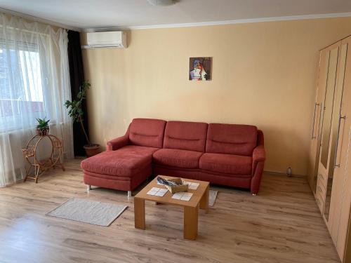 a living room with a red couch and a coffee table at Calm island near the Danube - free parking in Budapest