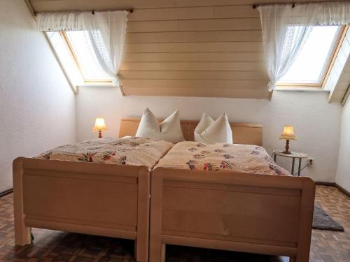 a bedroom with a large bed with two windows at Holiday Home Zerna by Interhome in Bad Muskau