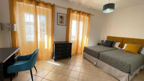 a bedroom with two beds and a desk and windows at Casa Azahar luxury ground floor apartment in Alhaurín el Grande