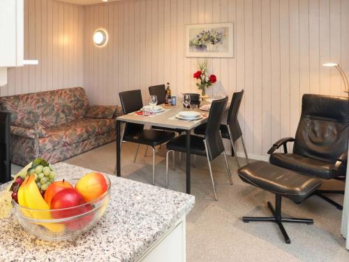 a living room with a table with a bowl of fruit at Apartment Arlette Nr- 34 by Interhome in Gstaad