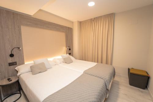 um quarto com uma grande cama branca num quarto em Lux Apartment em Melide