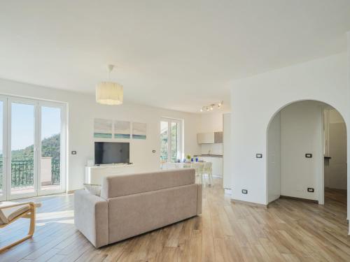 a white living room with a couch and a kitchen at Holiday Home Sorvegallo by Interhome in Moneglia