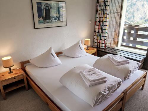 ディゼンティスにあるApartment Utoring Acletta-101 by Interhomeのベッドルーム1室(白いシーツと枕のベッド2台付)