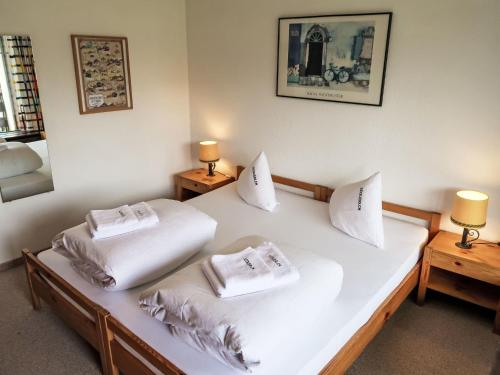 um quarto com 2 camas com almofadas brancas em Apartment Apt C 033 by Interhome em Disentis
