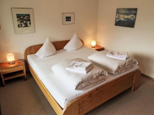 a bedroom with a wooden bed with two pillows at Apartment Apt A 086 by Interhome in Disentis