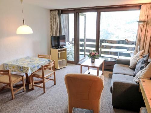 Apartment Utoring Acletta-9 by Interhome في ديسنتس: غرفة معيشة مع أريكة وطاولة