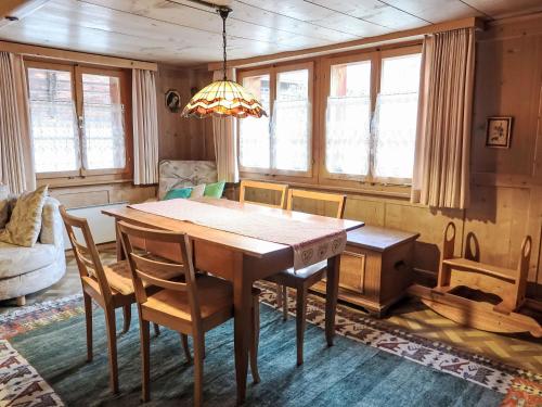 uma mesa de jantar com cadeiras e um lustre em Apartment Crestatgiet by Interhome em Rueras