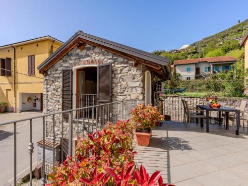 a small house with a balcony with a table at Holiday Home Pieve - GRV102 by Interhome in Gravedona