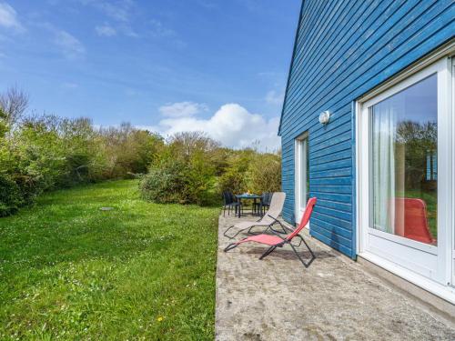 um pátio com uma mesa e cadeiras ao lado de uma casa em Holiday Home Maison bleue by Interhome em Kernalléguen