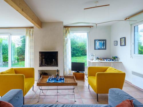 d'un salon avec des chaises jaunes et une cheminée. dans l'établissement Holiday Home maison bleue by Interhome, à Kernalléguen