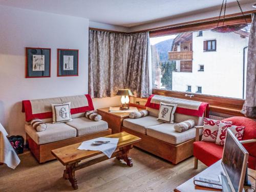 uma sala de estar com sofás e uma grande janela em Apartment Chesa Arlas E2 by Interhome em St. Moritz