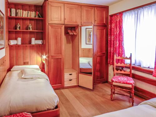 um quarto com 2 camas e uma cadeira em Apartment Chesa Arlas E2 by Interhome em St. Moritz