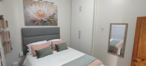 a bedroom with a bed with pillows and a mirror at Lasai Accommodation in Worcester