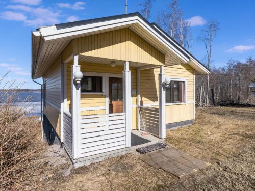 a small yellow tiny house with a porch at Holiday Home Villa-lyydia by Interhome in Niemikylät