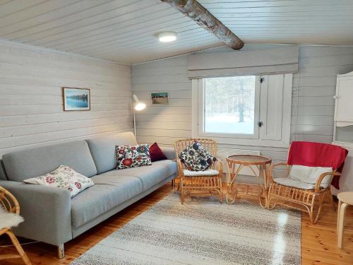 a living room with a couch and chairs and a window at Holiday Home Mukan maja by Interhome in Köngäs