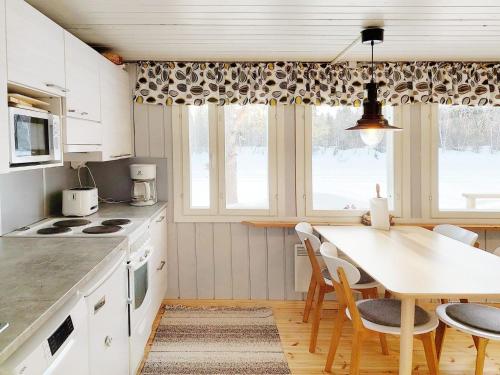 une cuisine avec une table et des chaises ainsi qu'une salle à manger dans l'établissement Holiday Home Mukan maja by Interhome, à Köngäs