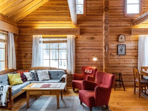 ein Wohnzimmer mit einer Couch und zwei Sesseln in der Unterkunft Holiday Home Outarinne by Interhome in Ylläsjärvi