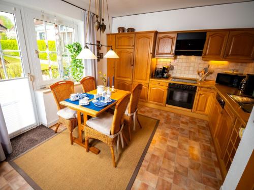 eine Küche mit einem Holztisch mit Stühlen, einem Tisch und einem Tisch in der Unterkunft Holiday Home Haus am Berg der Osterräder by Interhome in Lügde