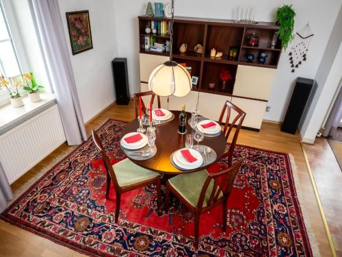 ein Esszimmer mit einem Tisch und Stühlen auf einem Teppich in der Unterkunft Holiday Home Haus am Berg der Osterräder by Interhome in Lügde